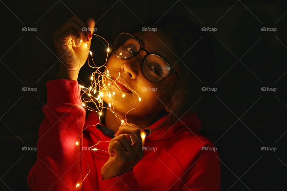 girl with fairy lights in dark background