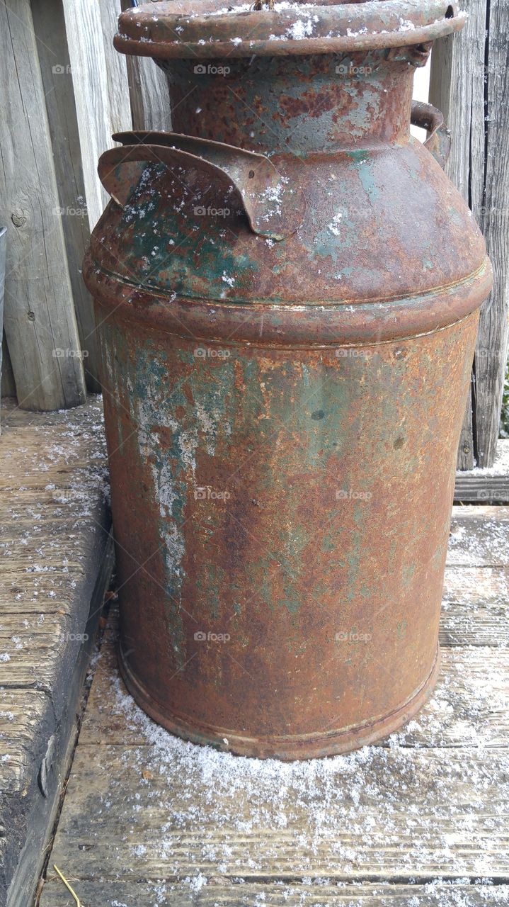 antique milk can getting snowed on