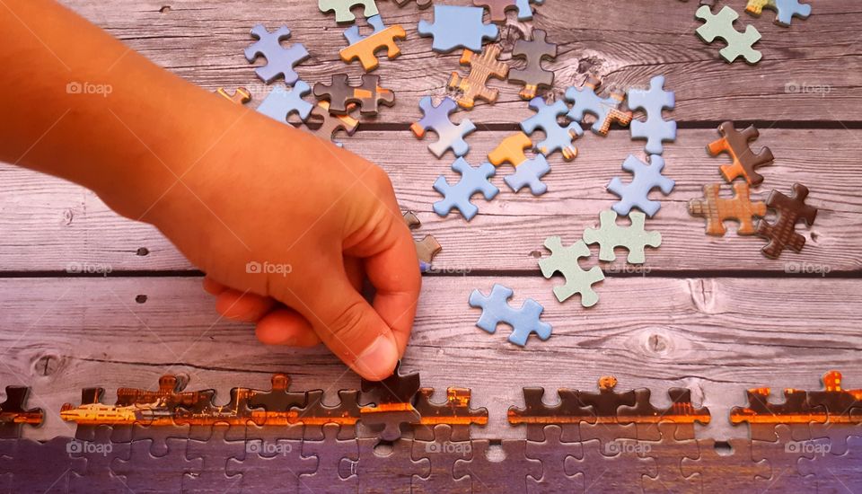 Boy hand holding jigsaw piece