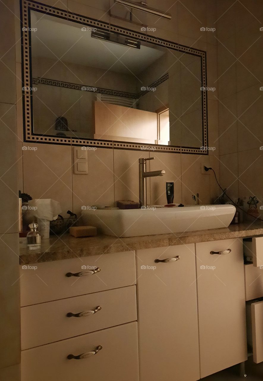 beige bathroom illuminated by side light from the corridor