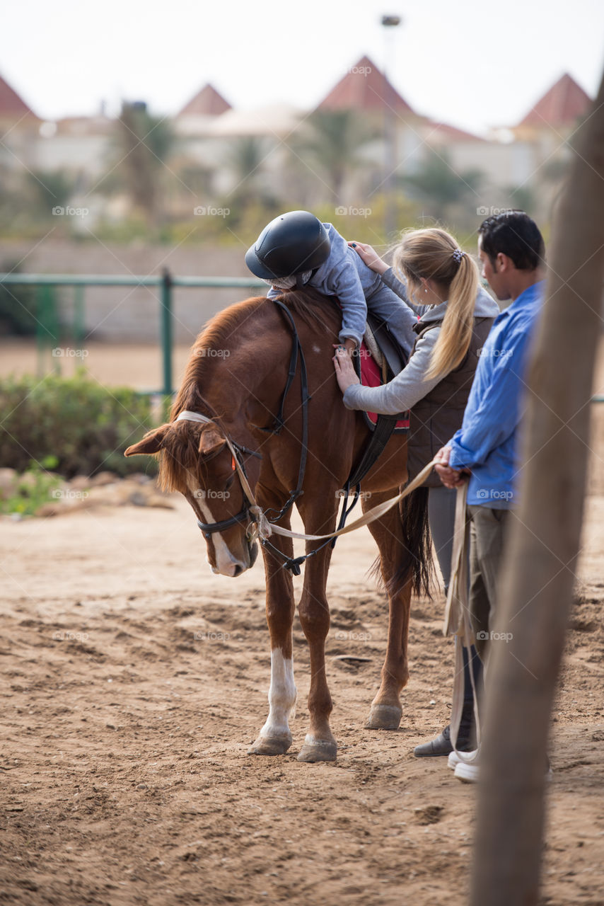 child on a horse hugging it