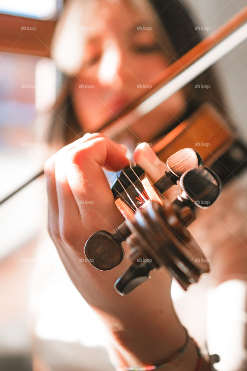 A girl play the violin in the house