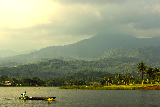 Mountain and lake with man on boat