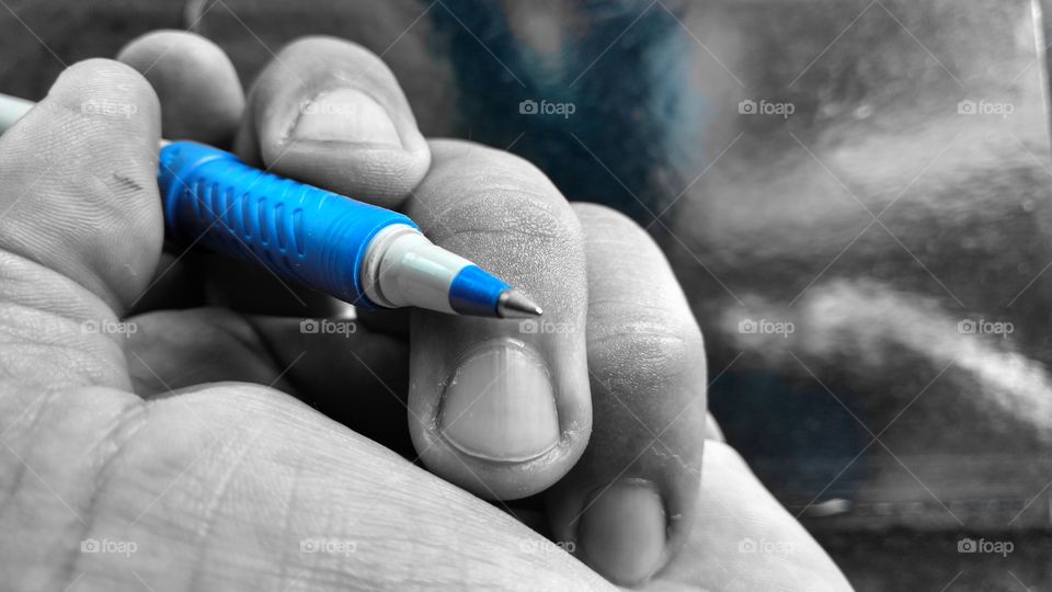 Mão em preto e branco, segurando a caneta.