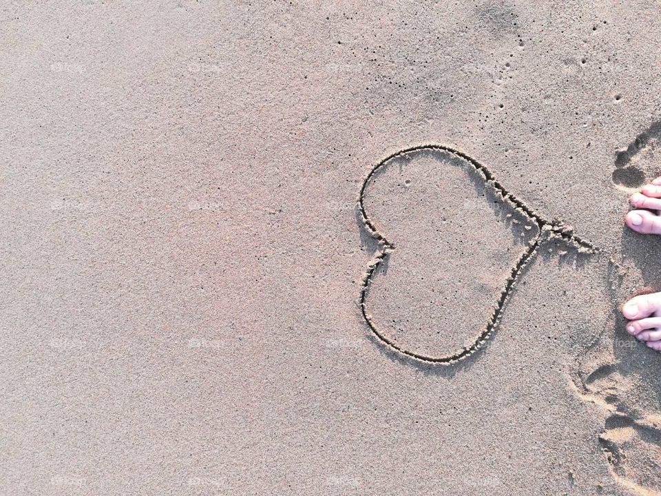 Heart drawn on sandy beach
