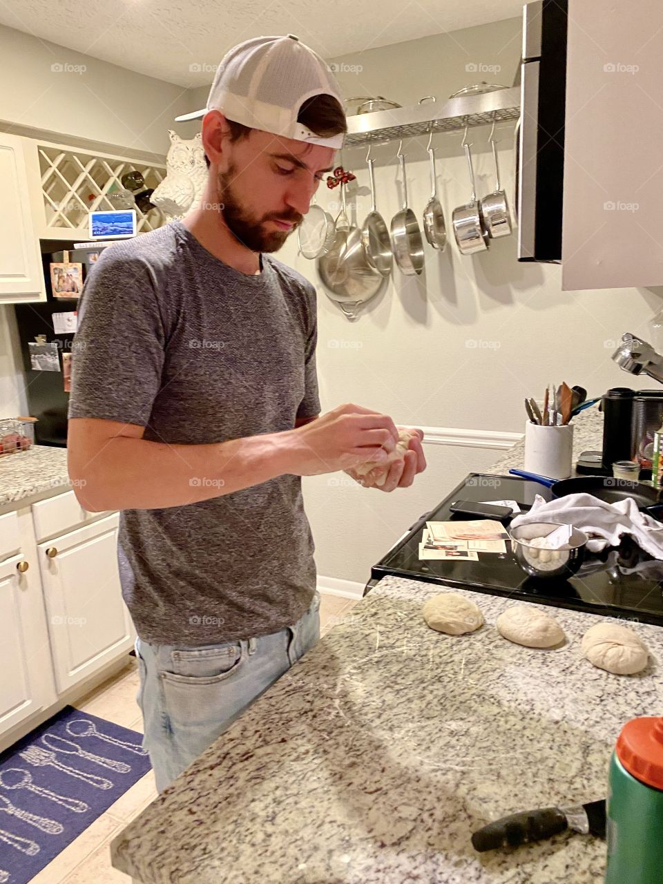 Man rolling dough balls for pizza