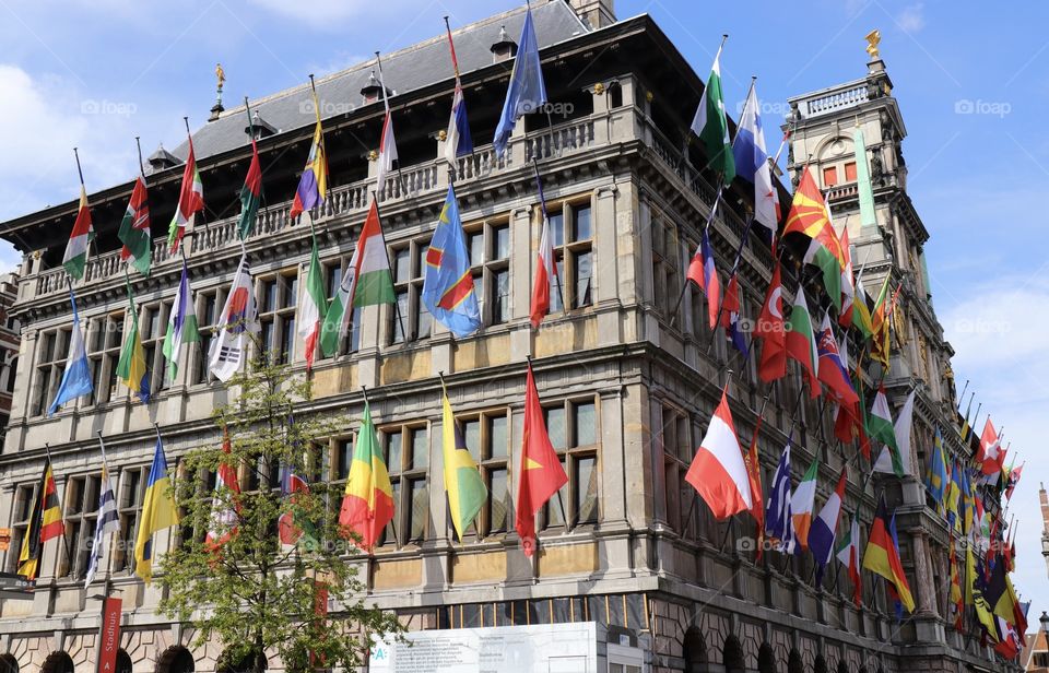 Many different colorful flags on the building in Antwerp in Belgium 