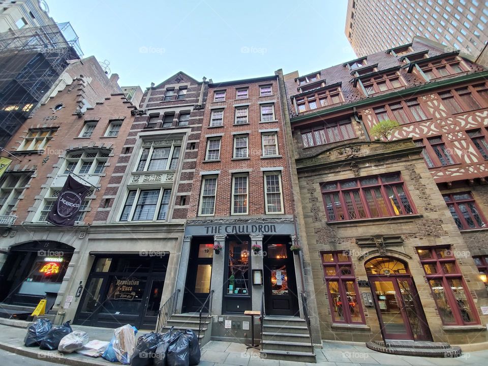 A row of older buildings sits in lower Manhattan and looks like something out of a movie