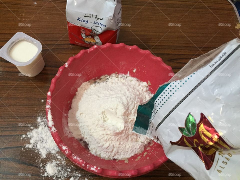 Adding flour to make pizza