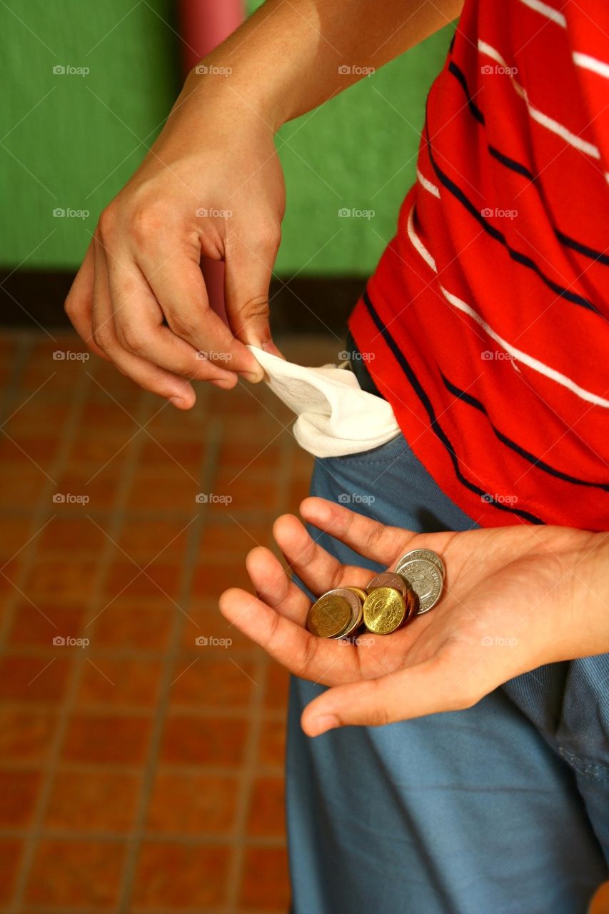 person holding coins in his hand and showing empty pocket