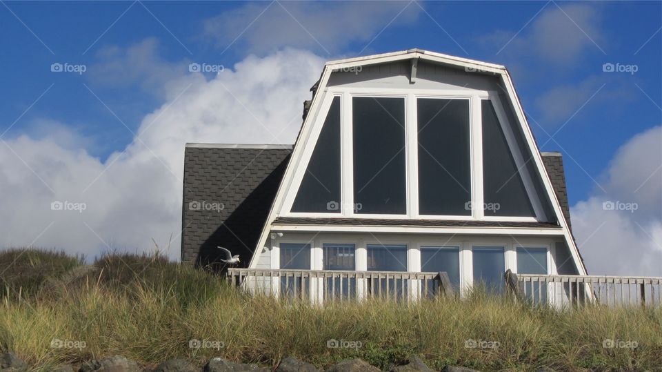 A Frame beach house up on a Sandy bank