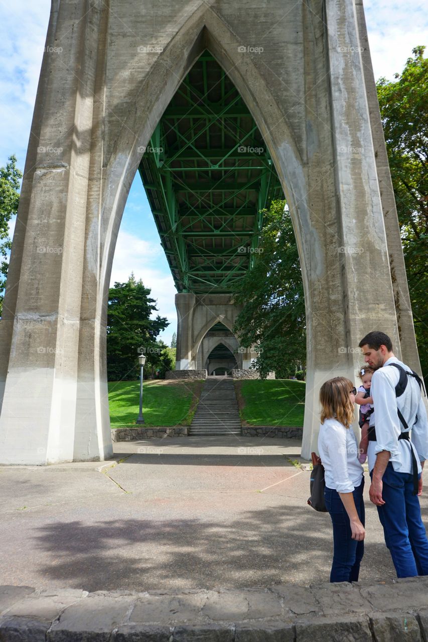Family standing under bridge