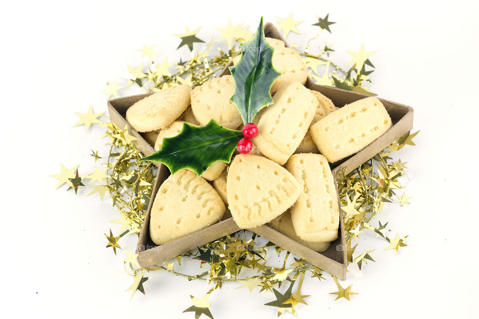 Crisp buttery Christmas shortbtread decorated with holly in a gift box.