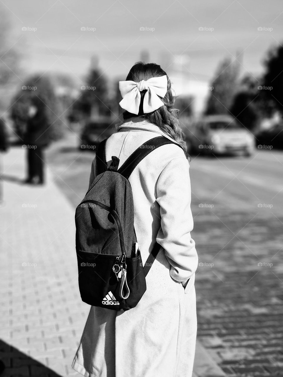 the girl with the bow is waiting for the bus