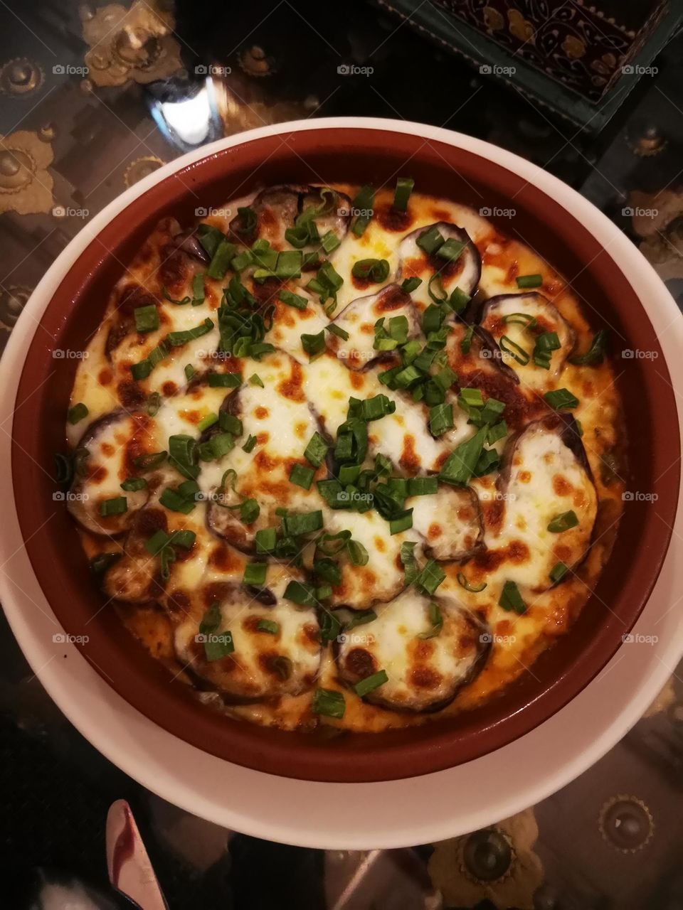 Fried eggplant with cheese and vegetables and a clay pot made of clay and a little pepper