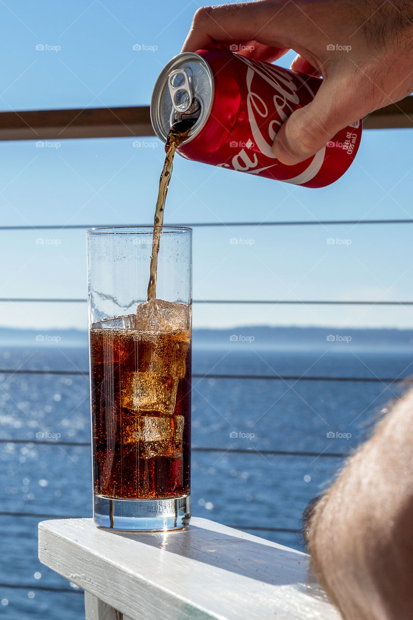 Pouring coke over ice bubbles 