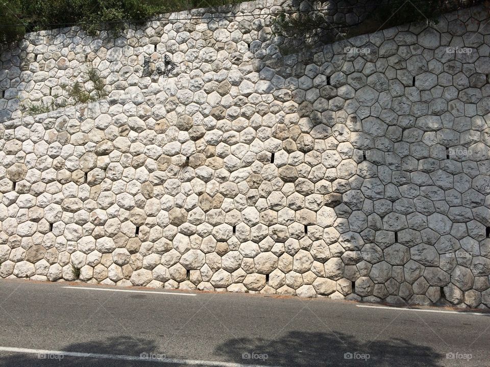 Geometric stone retaining wall. Stone wall in Nice, France