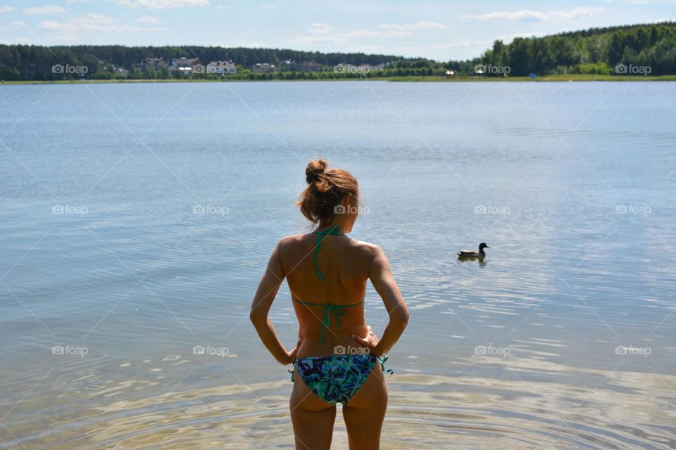 woman in swimsuit relaxing on a lake summer time, vacation