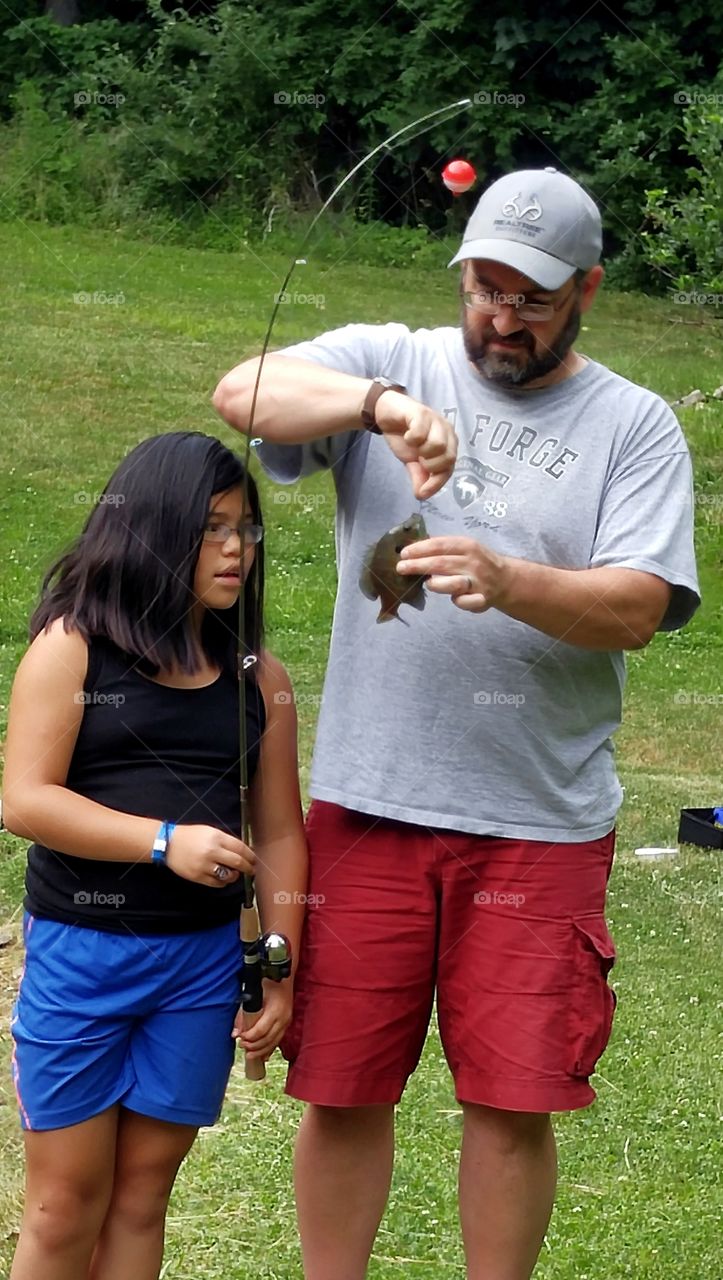 Father and daughter holding fish