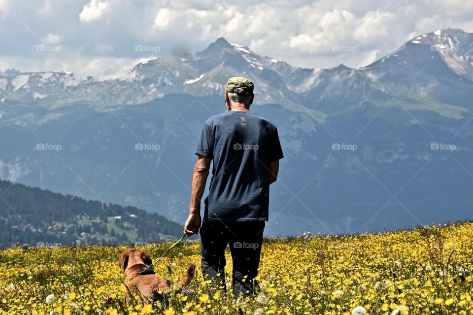 man with dog in meadow.