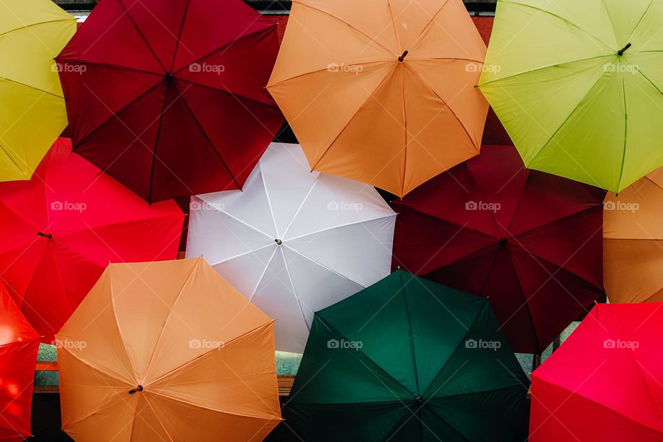 Beautiful view of colorful open umbrellas that are installed on the wall, close-up side view.