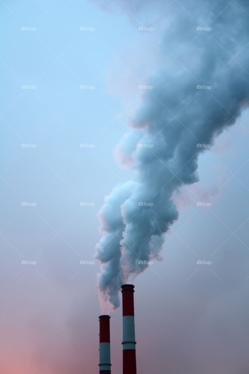 Industrial smoke from chimney on blue sky