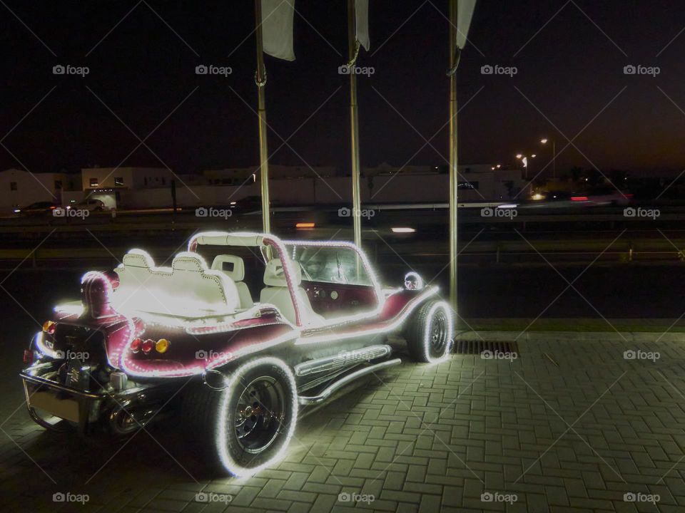 coche buggy antiguo con iluminación navideña tomada en la oscuridad de la noche.
