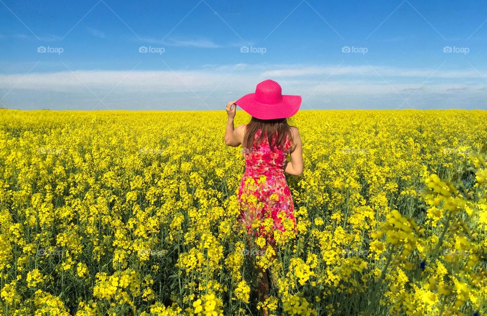 Rear view of women standing in flowers field