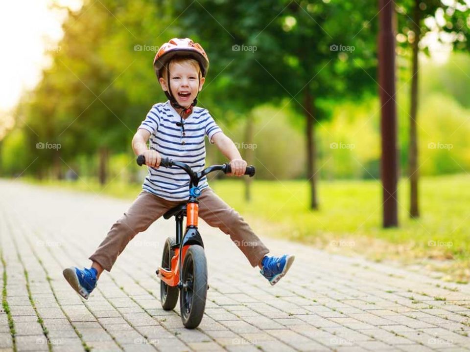 Kid riding bicycle with helmet funny.