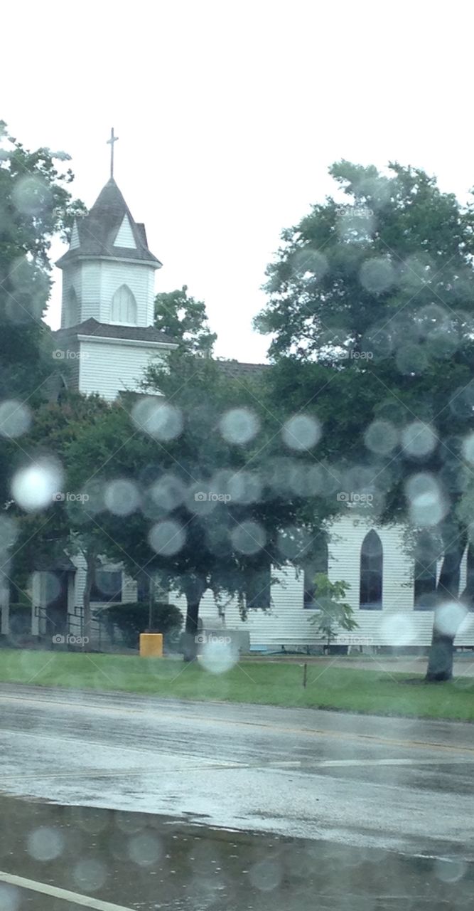 Rainy day. Church through a window covered in rain