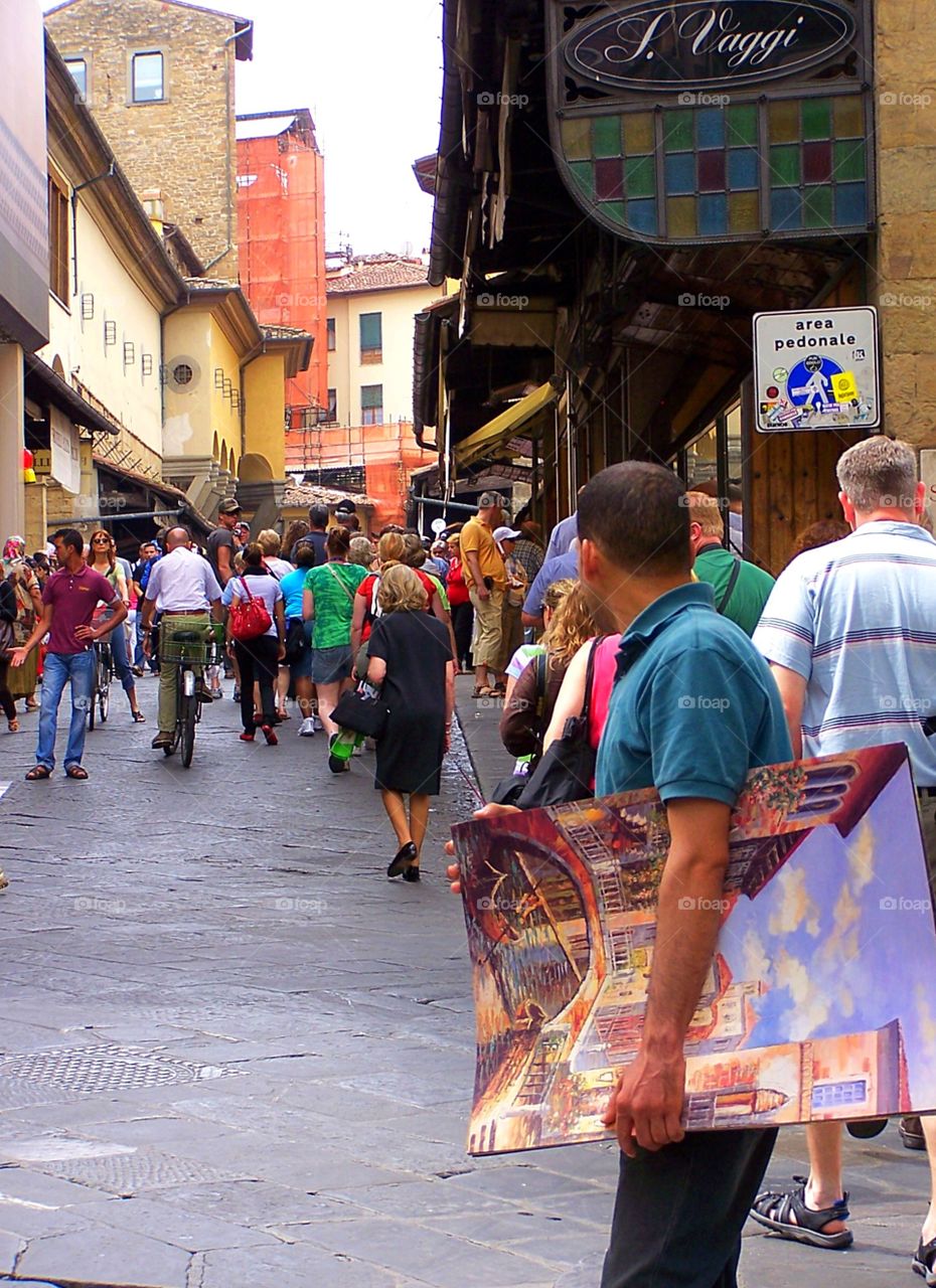 Man selling oil paintings on the street in Florence, Italy