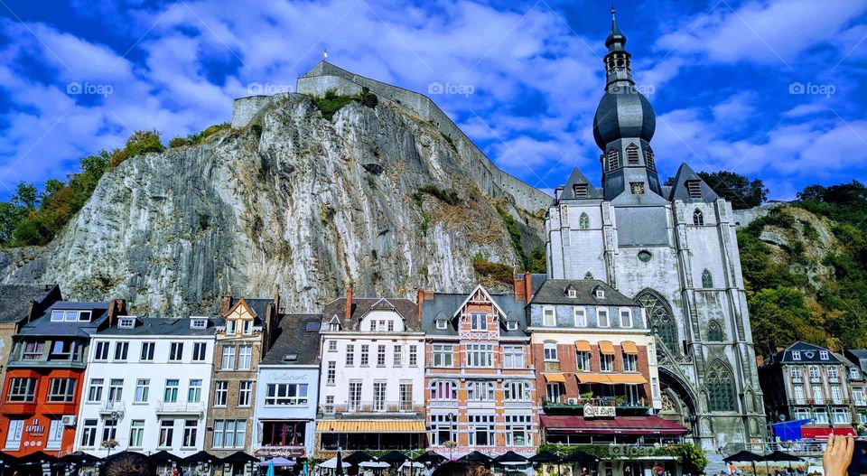 Beautiful fairy tale and colorful houses with a castle church of the medieval era in the city of Dinant in Belgium from the view of a boat floating on the river, close-up side view.