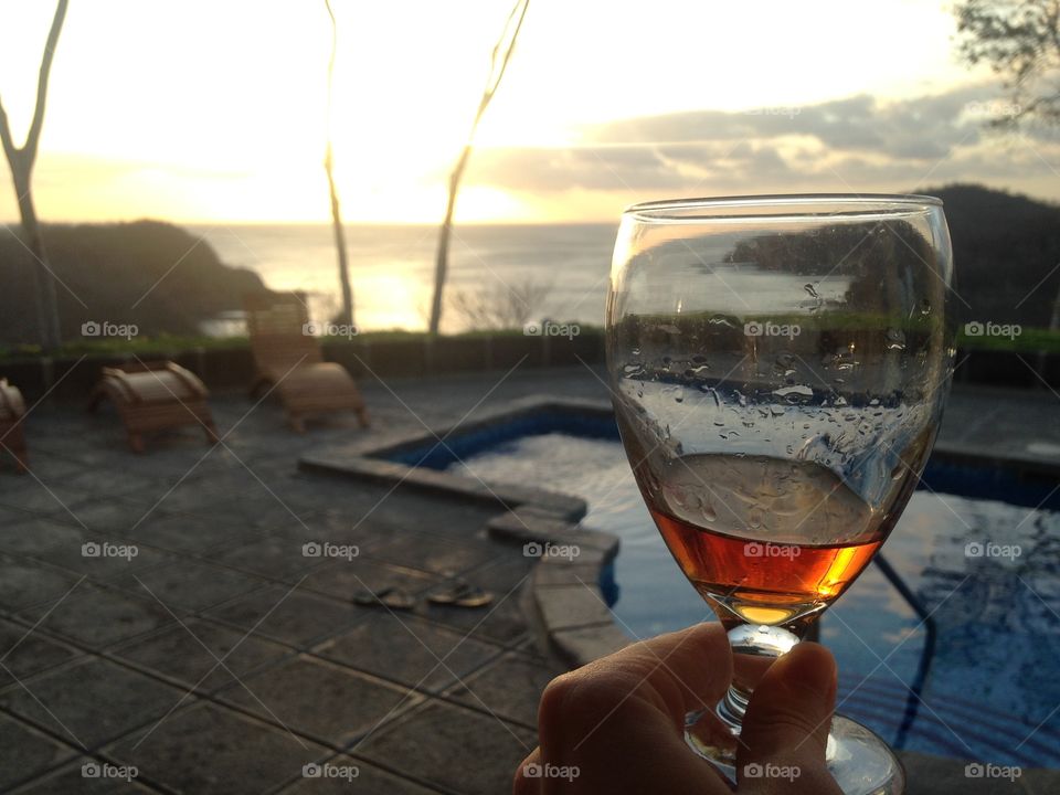 Celebrating life at sunset with a glass of rum