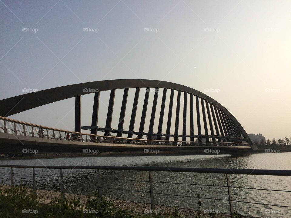 Curved bridge in modern architecture over the lake