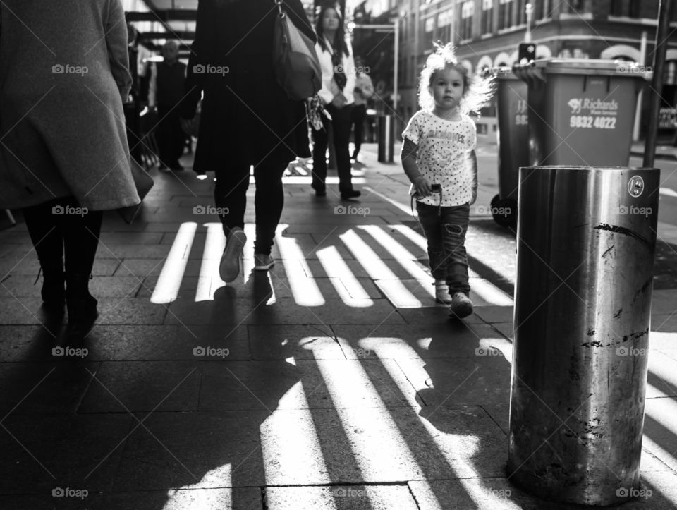 A little girl walking on street in the city