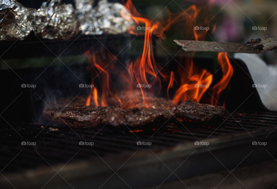 Flames, burgers and a grill all make for the best summer cookout with your closest friends. 