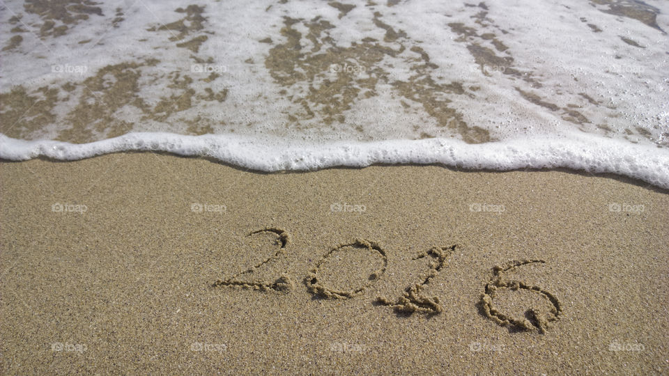 Beach with wave and 2016 year. wave and beach with 2016 year text on the sand