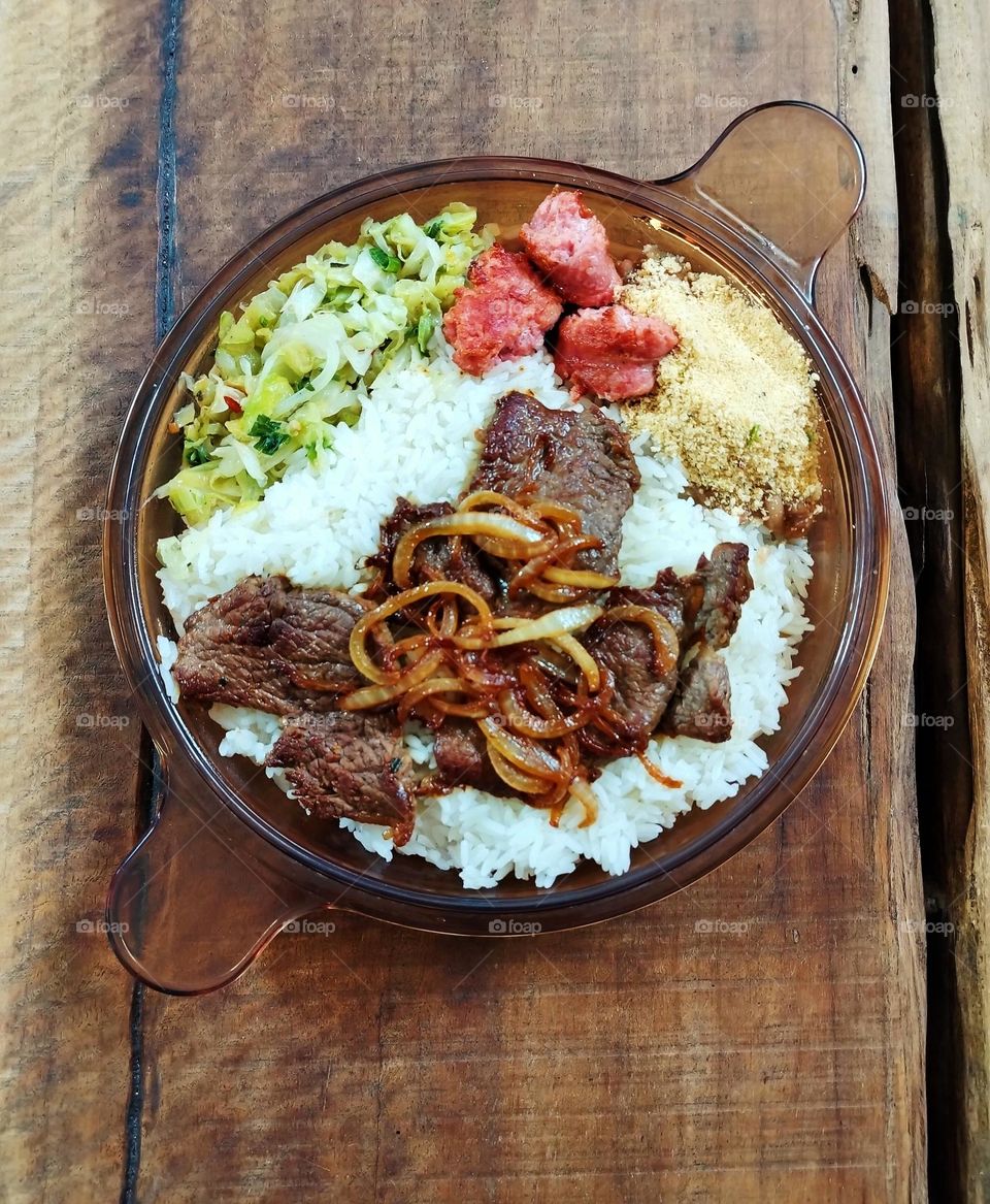 Prato típico brasileiro com arroz, feijão e farinha, bife com cebola linguiça frita e legumes refogados... Que delícia!