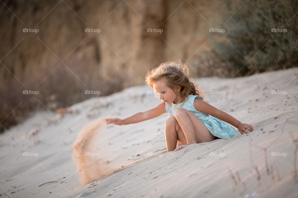 Little girl playing in the sand 