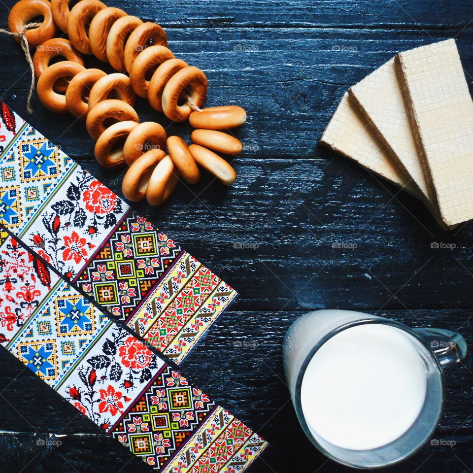 cakes, a cup of milk, bagels and waffles on a black background