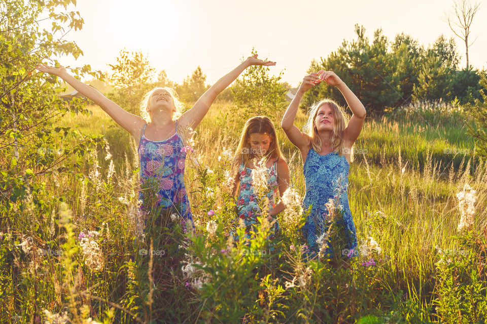 Summer vibes. Girls are walking on hayfield on the countryside