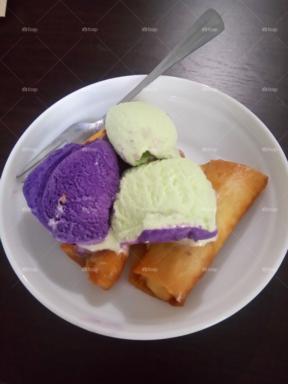 homemade banana crepe with ice cream on top.[turon in the Philippines ]