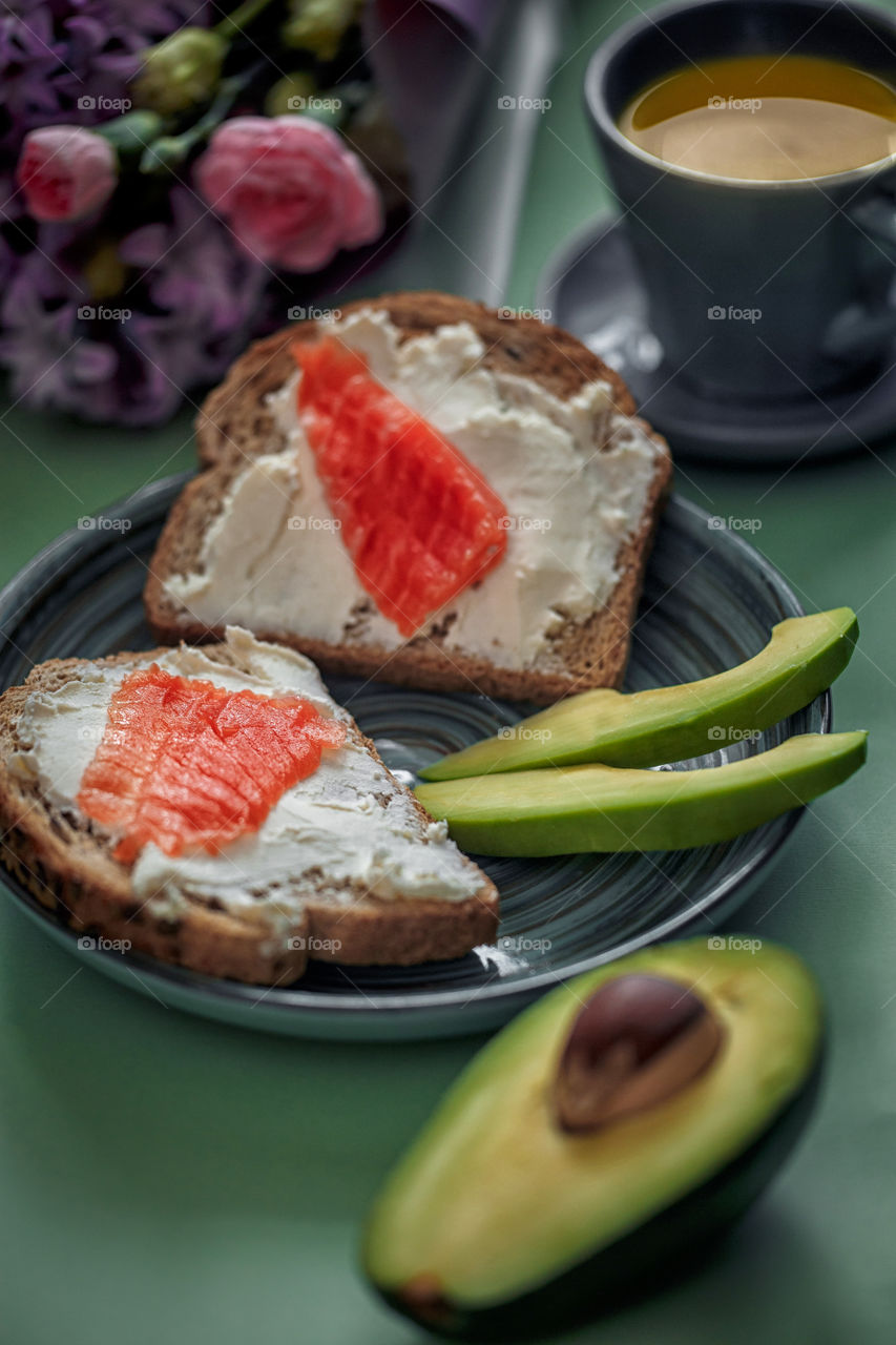 Breakfast with toast with cream cheese, red fish and avocado 