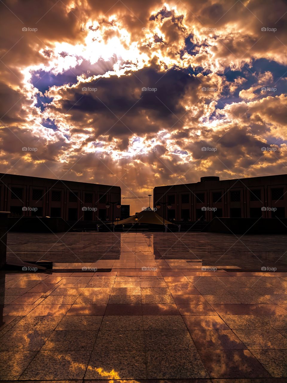 Golden Sunset hides in between clouds +sun rays 