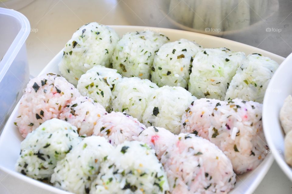Pink and white Onigiris with seaweed. Rice balls. Japanese food.