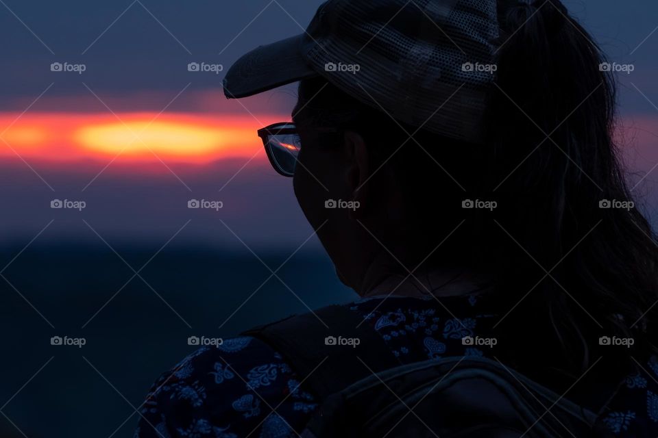 A young woman gazes off at the sunset. North Carolina. 
