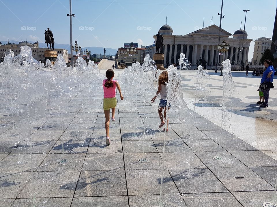 kids running through fountain splash