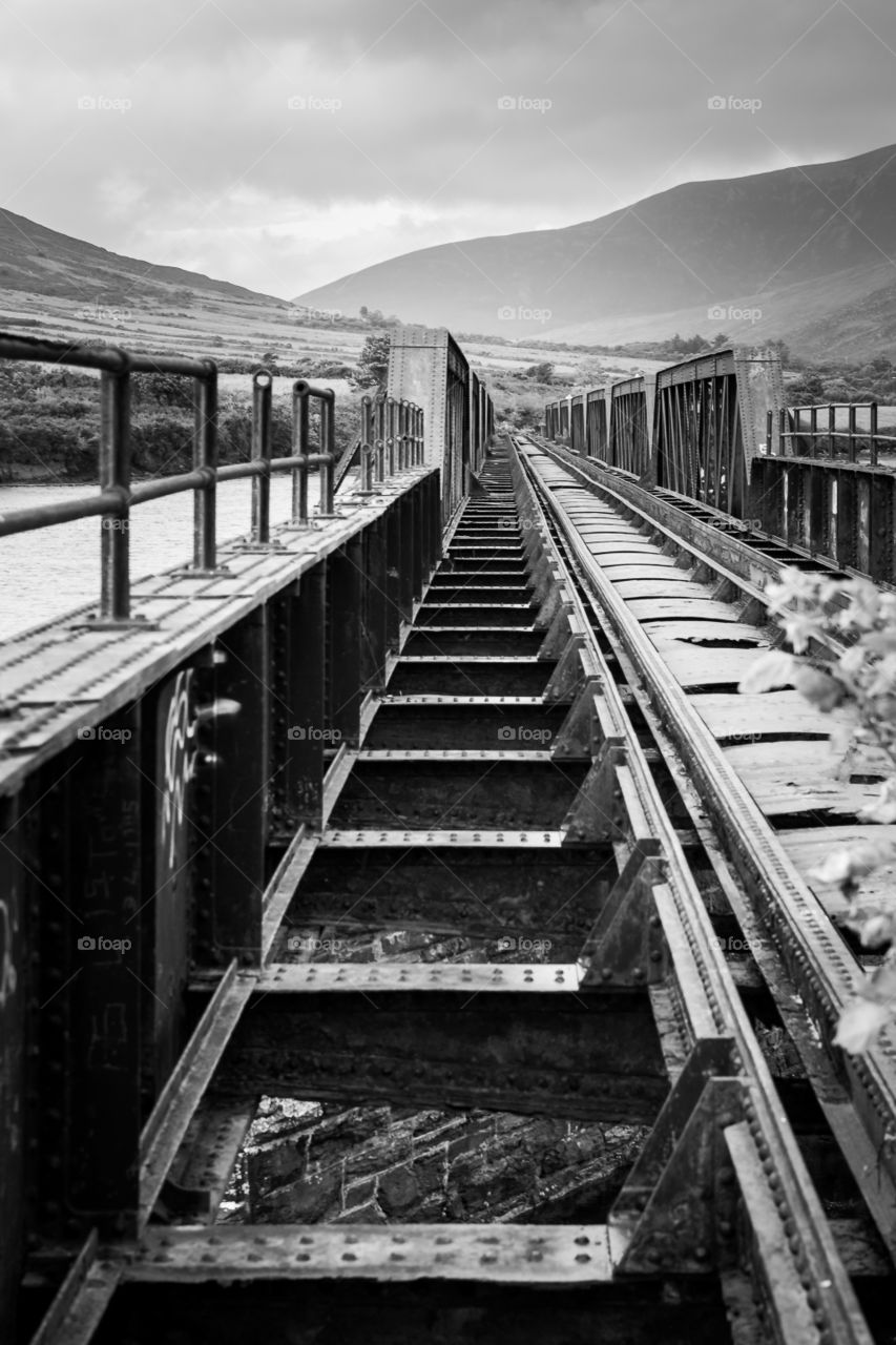 Train tracks and steps leading over a bridge into the distance