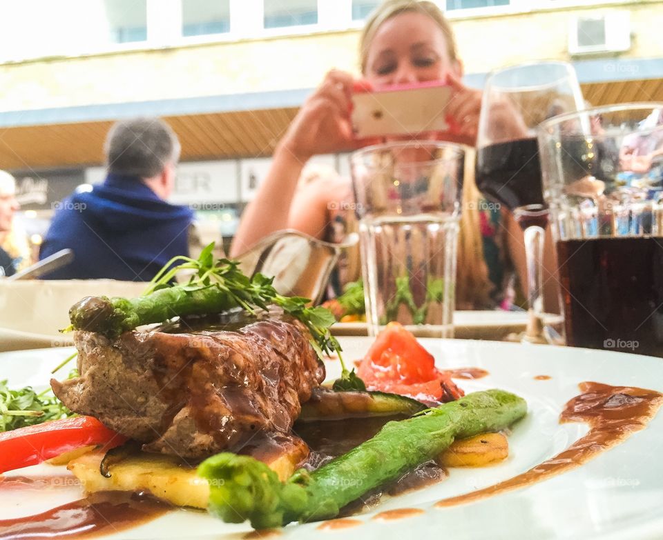 One of the most popular selfies people take is on their food. Young woman taking a food selfie at a local restaurant in Växjö Sweden.