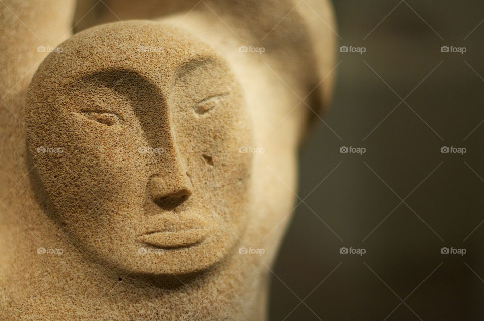 Close up of a face carved from a whale bone